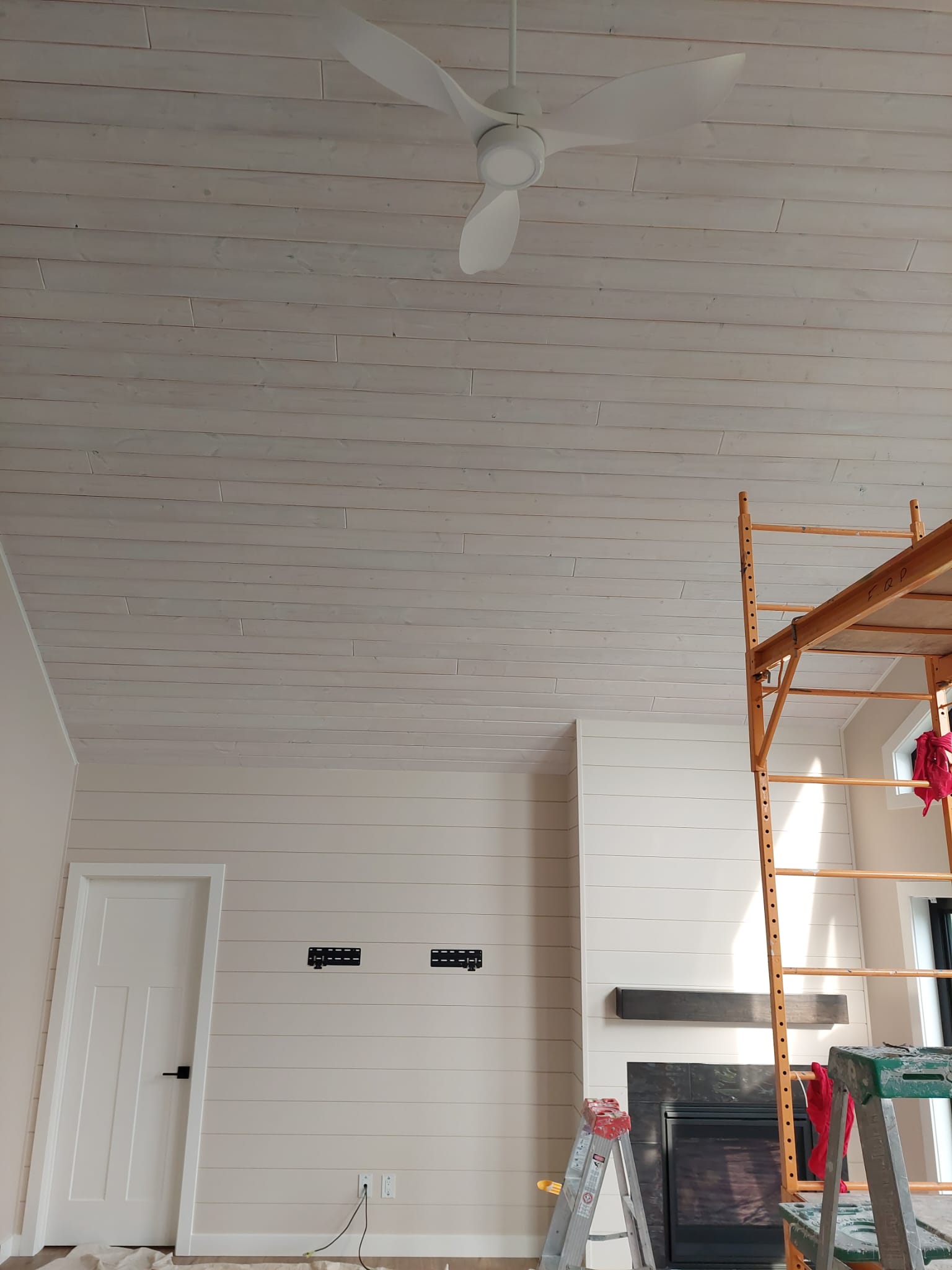 Finished whitewashed shiplap ceiling and fireplace feature wall